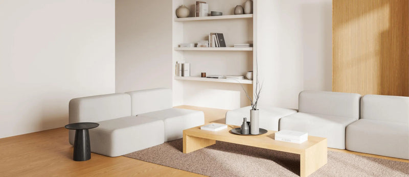 Modern living room with white sofa, wooden coffee table, and bookshelf.