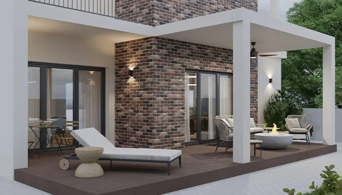 Modern outdoor living space with lounge chairs, tables, and a brick wall.